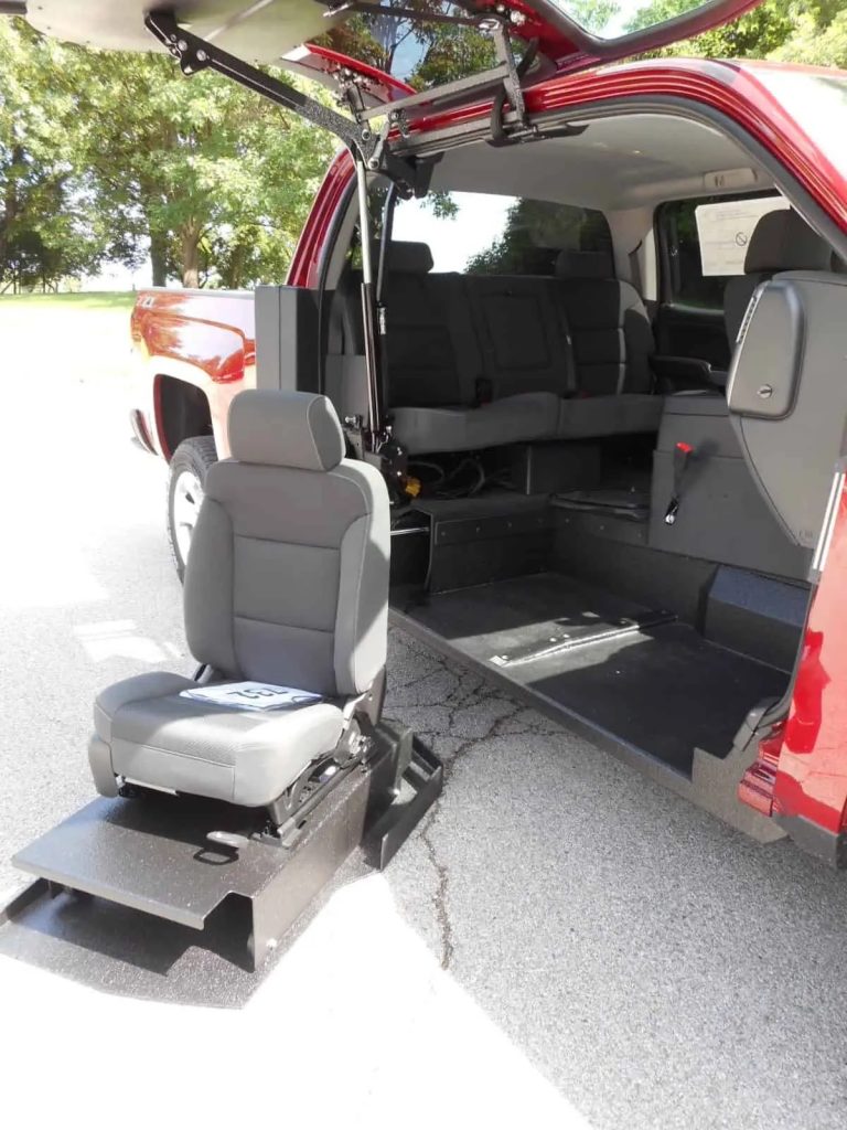 A close-up of a passenger seat in a truck on a hydraulic lift. The chair is deployed outside the truck.